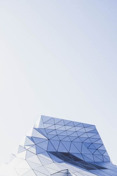 Striking modern building with geometric facade against clear sky.